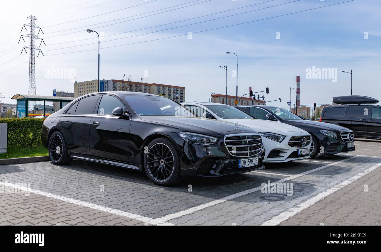 A picture of three vehicles at a Mercedes Benz car dealership, in