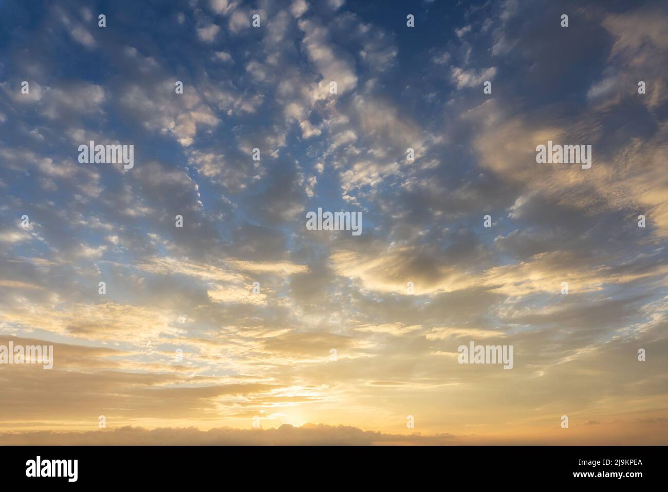 cloudscape of orange clouds on sky at sunset Stock Photo