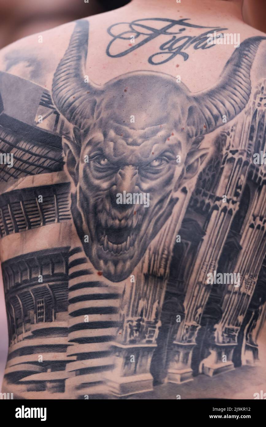 Sassuolo, Italy, 22nd May 2022. Tattoos of the Duomo of Milan, the San Siro  Stadium and the Devil are seen on the back of an AC Milan fan during the  Serie A, image size:867x1390