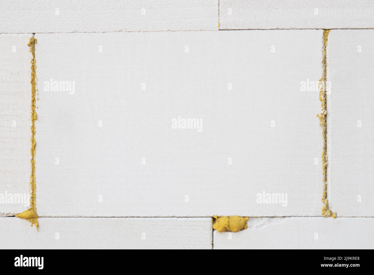 Wall of foam concrete blocks glued together with building glue. Close