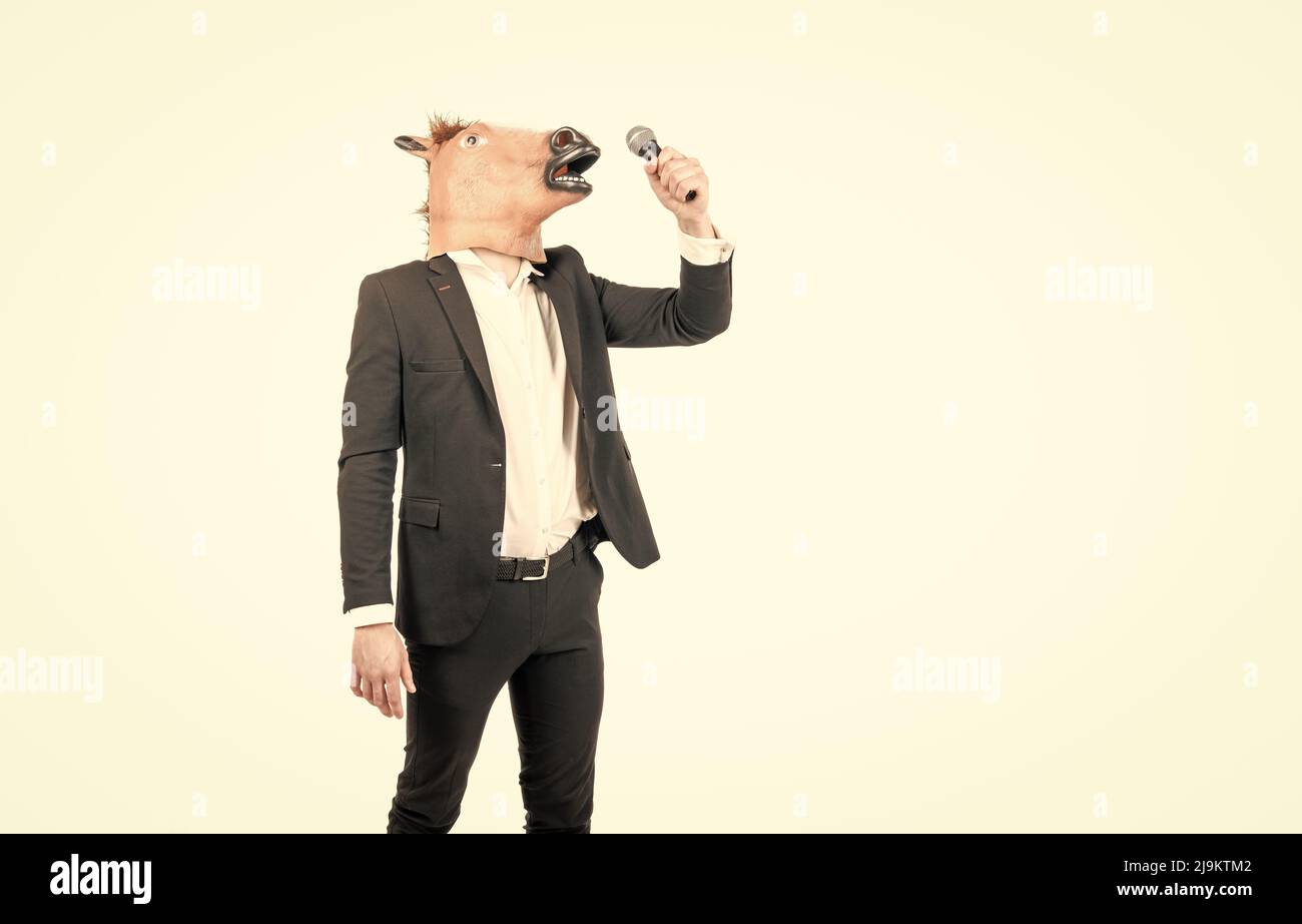 Professional man wear horse head mask in formalwear singing karaoke