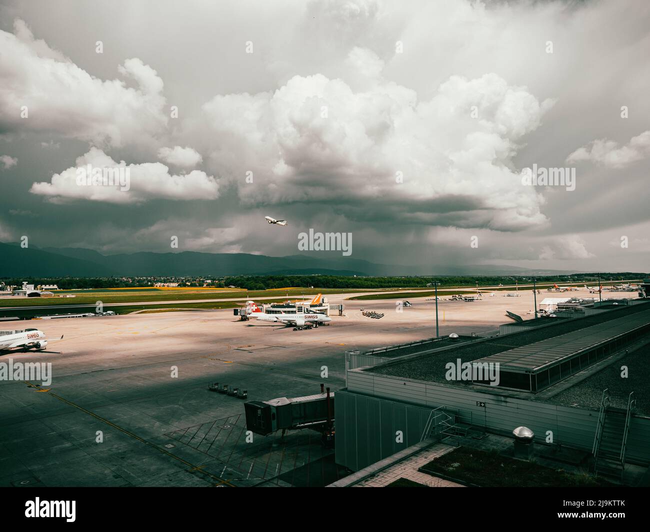 Airport of Geneva, Switzerland. Planes and service vehicles stand on the runway and taxiway of Geneva airport in Switzerland. Stock Photo