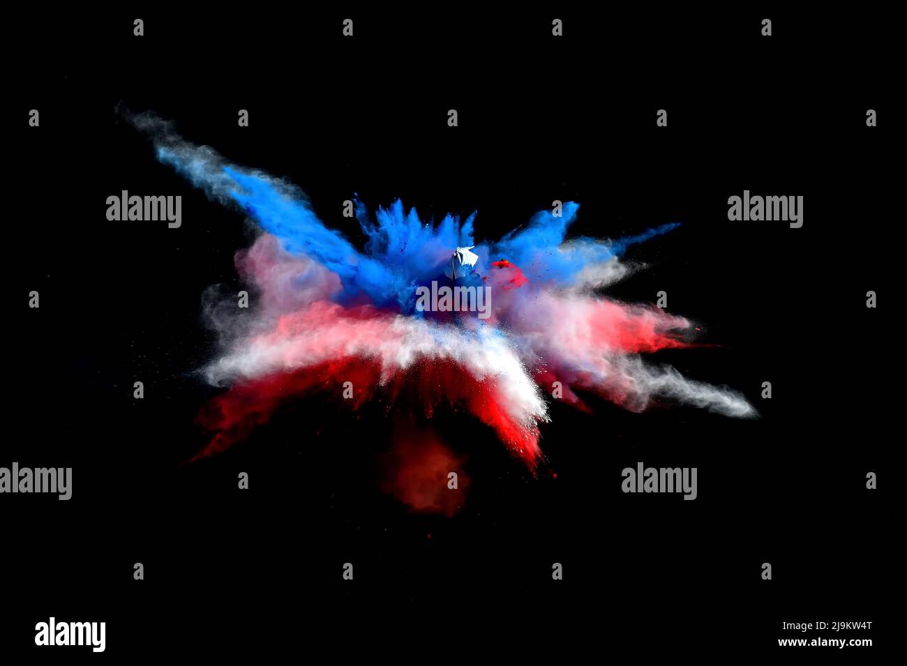 Red, white and blue forms of powder paint combined  together explode in front of a black background to give off fantastic powder paint explosions. Stock Photo