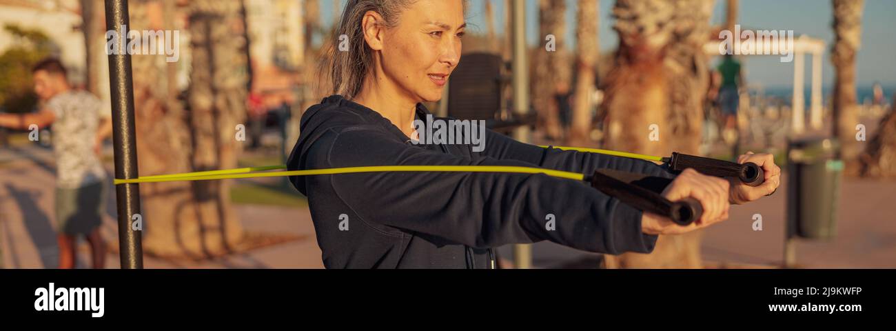 Sporty female doing arms stretching outdoors in the evening Stock Photo