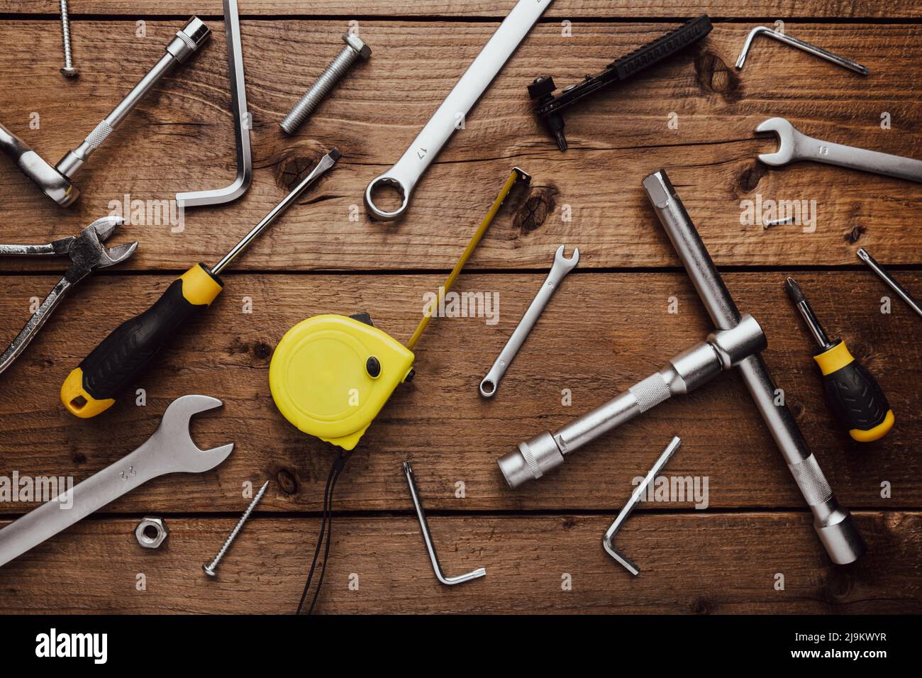 Flat lay with DYI composition of various work, carpentry tools knolled on brown wooden decks background pattern working table. Top view on new hand tool set for repair and construction kit, overhead Stock Photo
