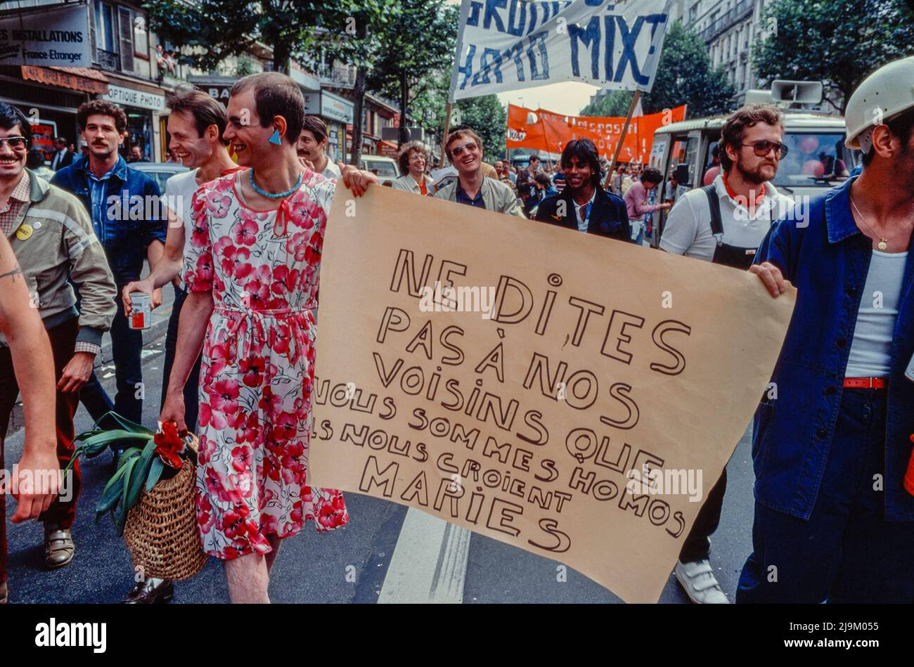 Paris, France, Large Crowd of People, LGBTQI, MAn in Dress Marching with Funny Protest Signe 'Don't Tell our Neighbors...' Gay Pride March, 1982, 1980s Archives, France, gay protest vintage Stock Photo