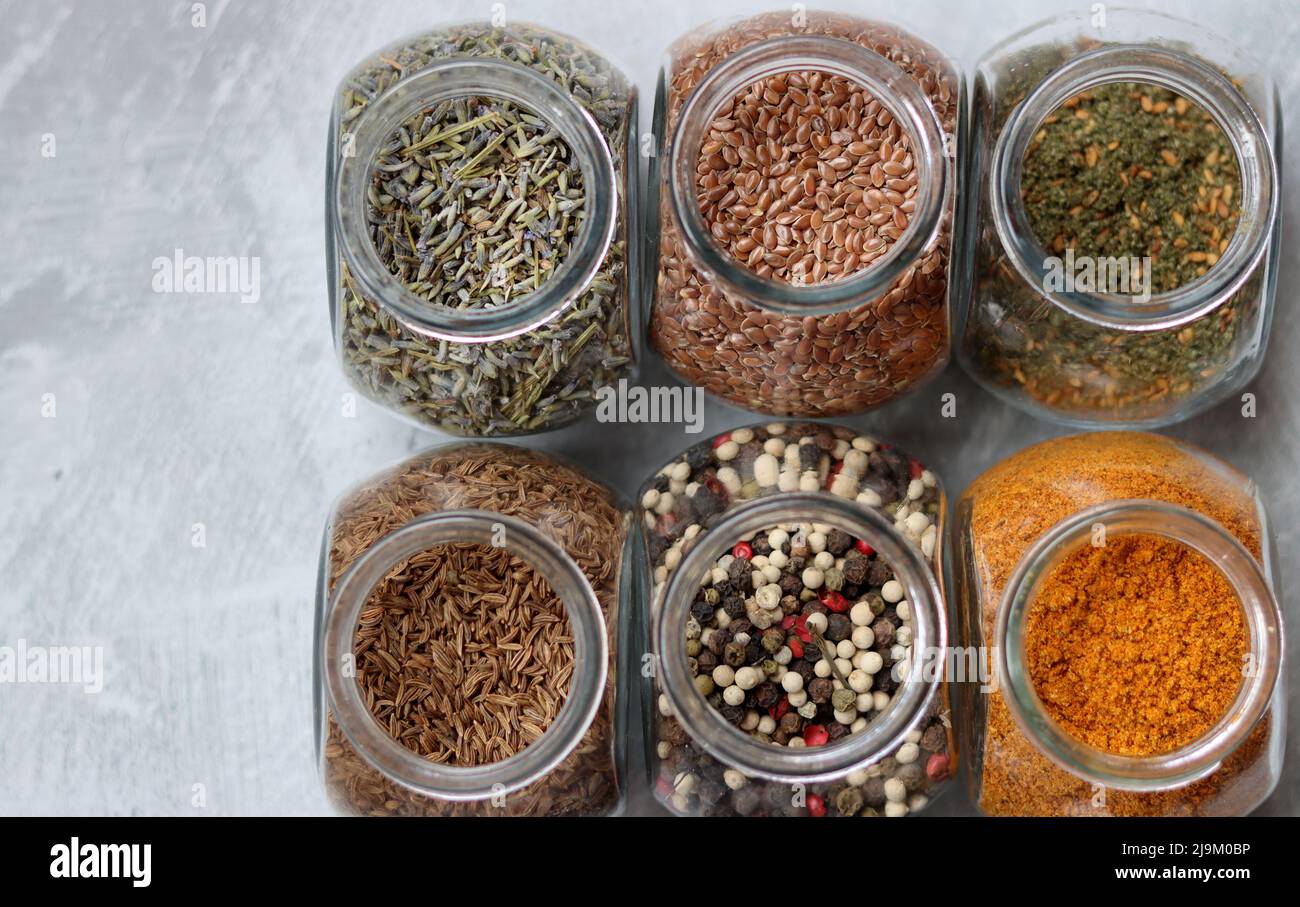 Small glass jars with different spices. Peppercorn, cardamom, turmeric