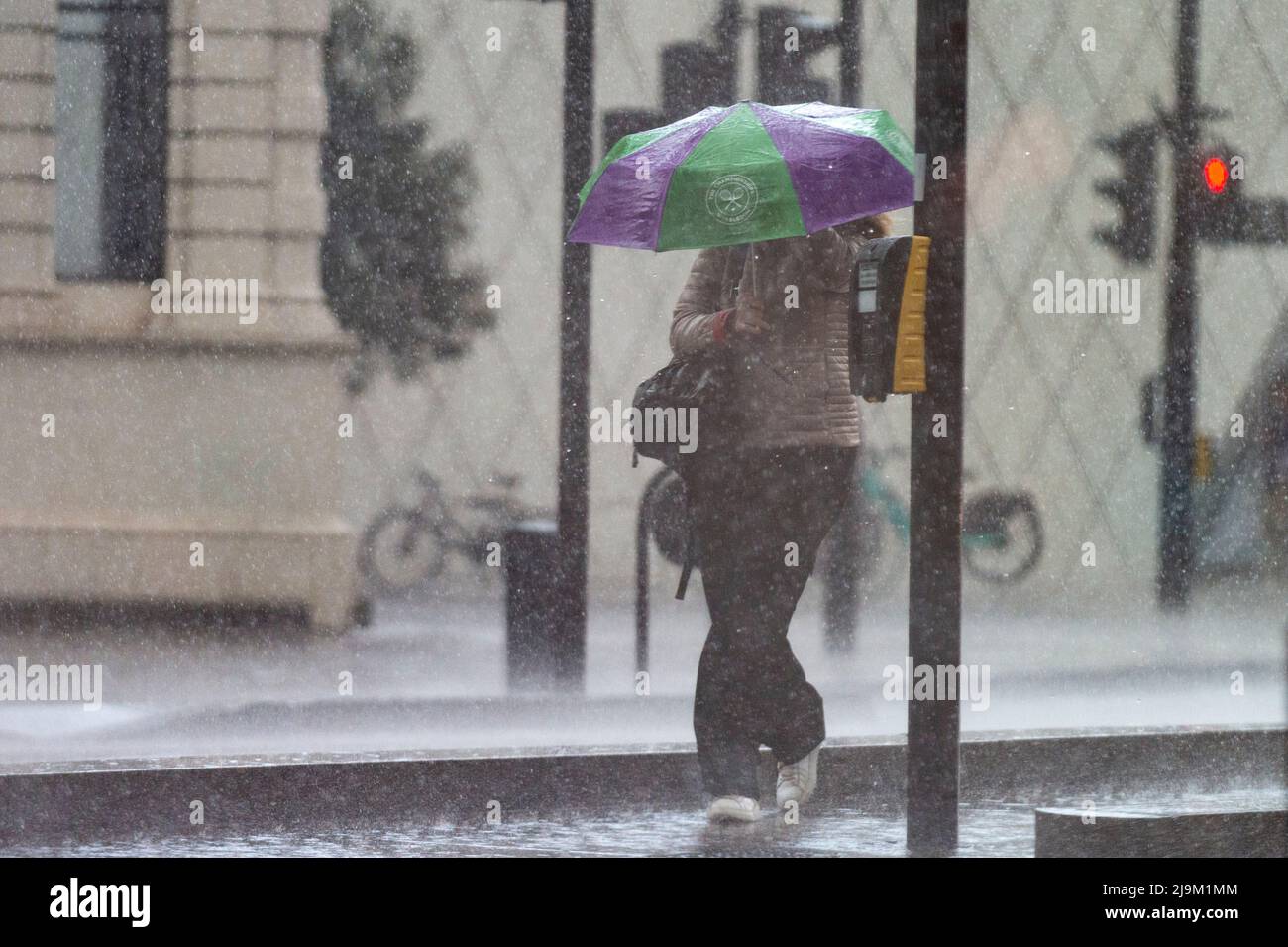 London, UK.  24 May 2022. UK Weather : A woman is caught in a sudden and very heavy downpour preceded by thunder and lightning in Southwark.   The forecast is for continuing mixed conditions for the rest of the day in the capital.  Credit: Stephen Chung / Alamy Live News Stock Photo