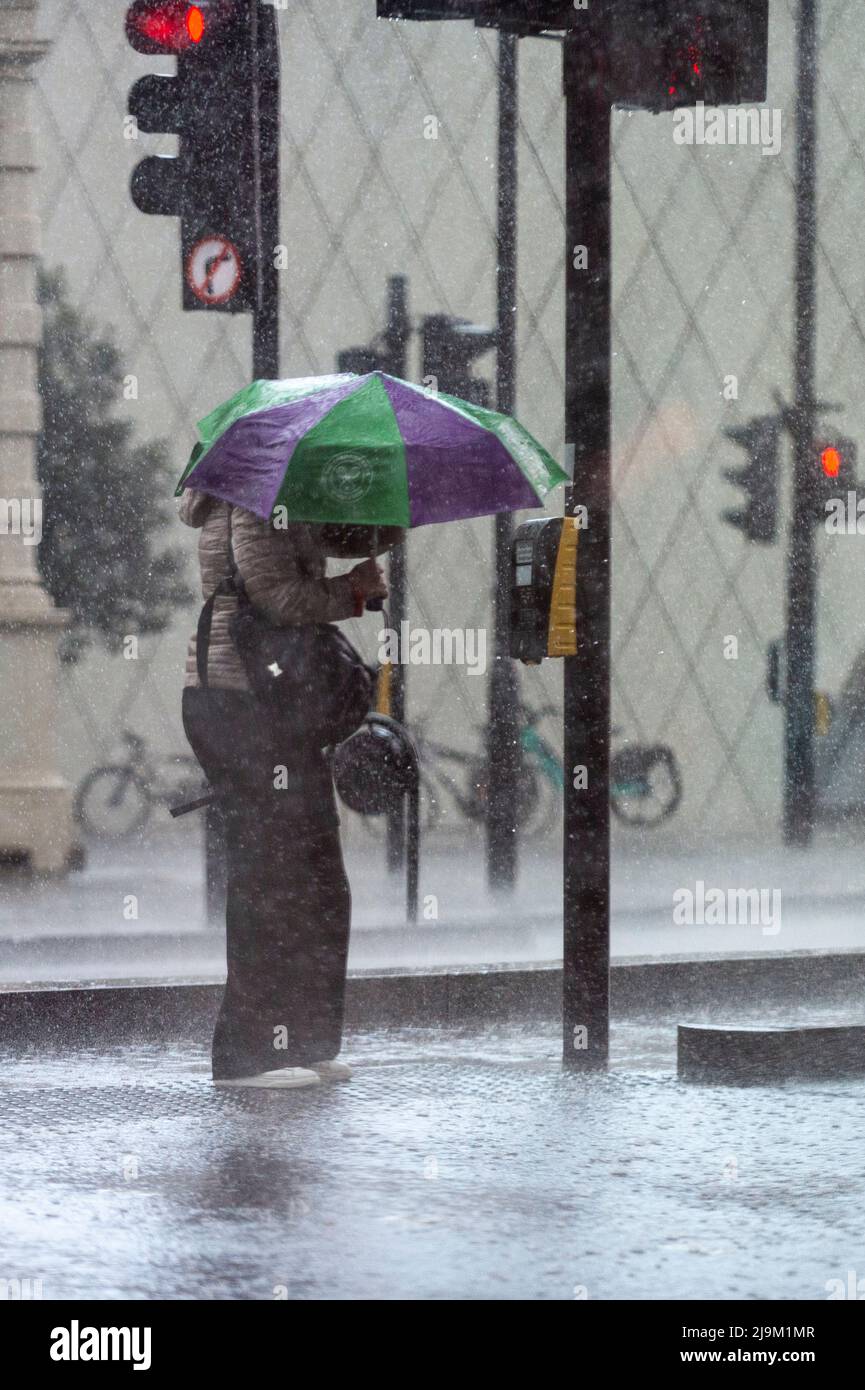 London, UK.  24 May 2022. UK Weather : A woman is caught in a sudden and very heavy downpour preceded by thunder and lightning in Southwark.   The forecast is for continuing mixed conditions for the rest of the day in the capital.  Credit: Stephen Chung / Alamy Live News Stock Photo