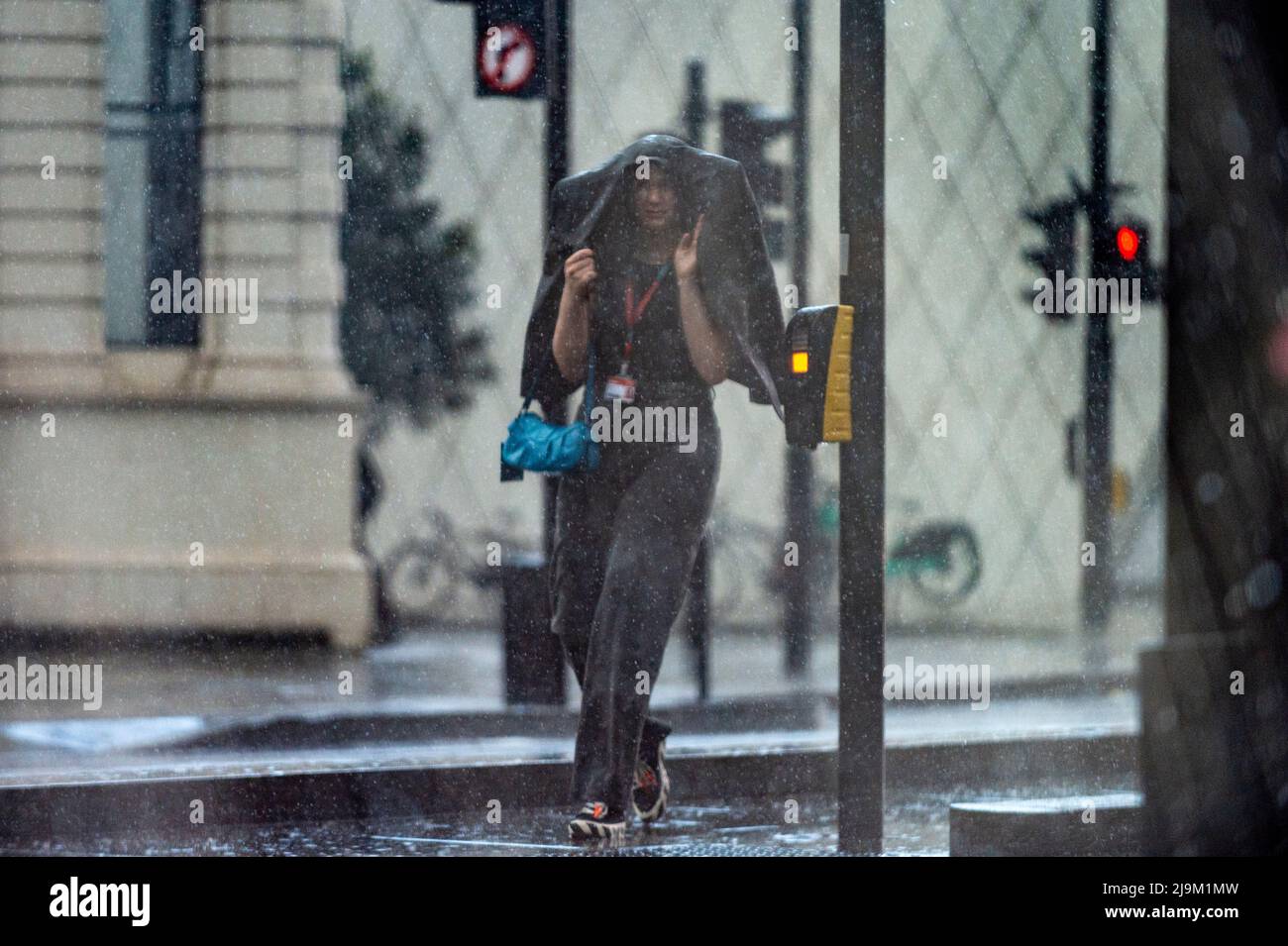 London, UK.  24 May 2022. UK Weather : A woman is caught in a sudden and very heavy downpour preceded by thunder and lightning in Southwark.   The forecast is for continuing mixed conditions for the rest of the day in the capital.  Credit: Stephen Chung / Alamy Live News Stock Photo