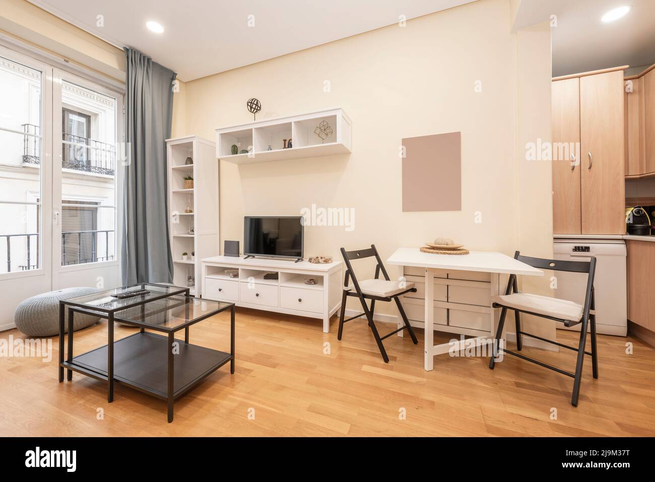 Living room with white wooden furniture, matching folding dining table