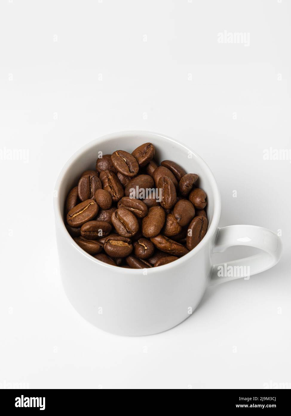 Perfect small white coffee cup with roasted coffee beans on white