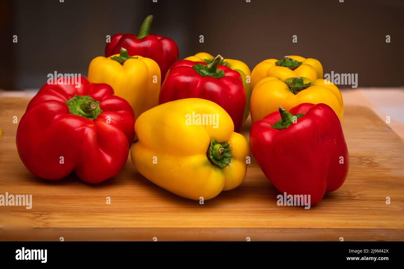 Close up of assorted red and yellow bell peppers placed on a cutting