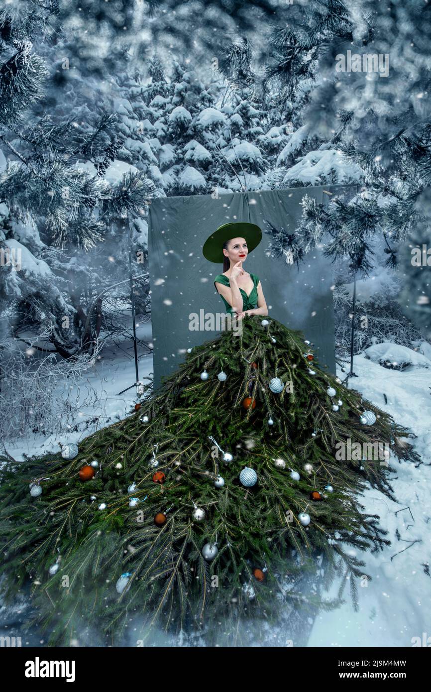 Beautiful woman with christmas tree dress in winter forest Stock Photo -  Alamy