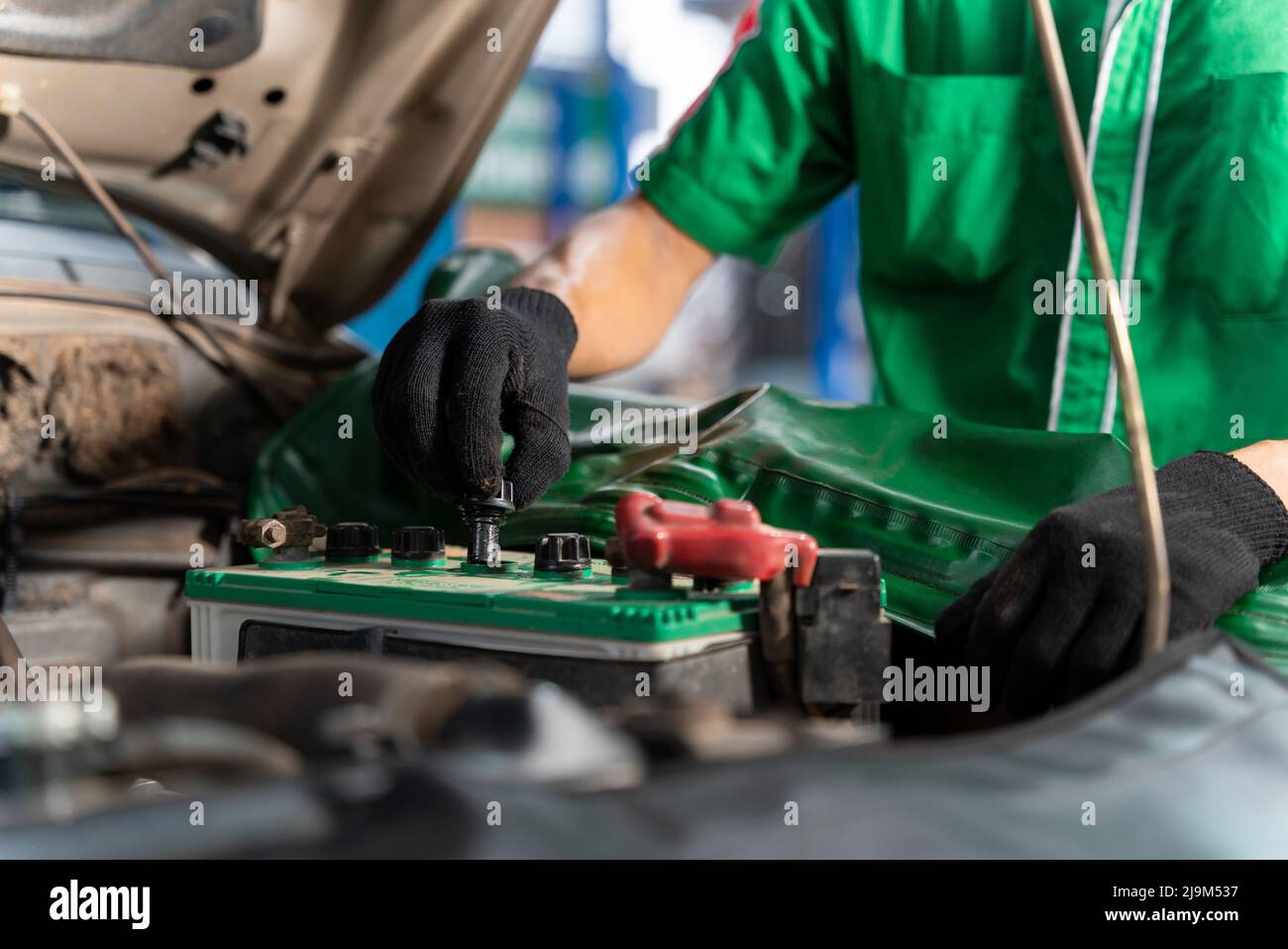 Auto mechanic checking battery for the customers who come to use the