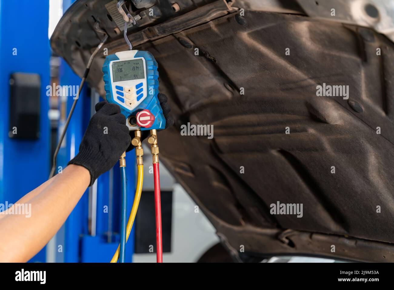 Auto mechanic use a thermometer and fill the car's air conditioner in