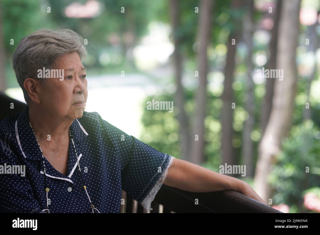 old elderly elder senior woman resting relaxing on balcony near garden Stock Photo