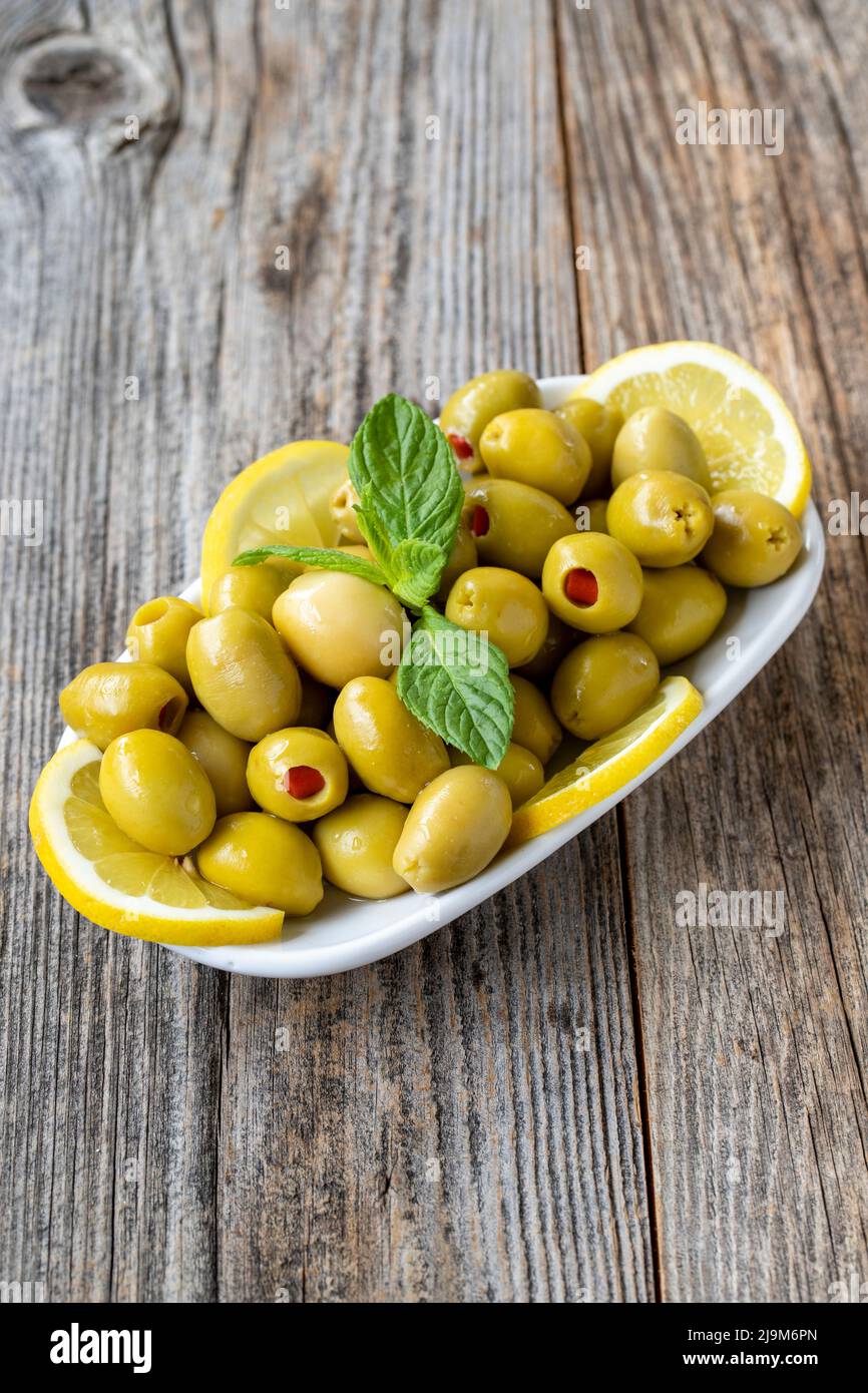 Green olives stuffed with peppers. Natural peppered olives on wood