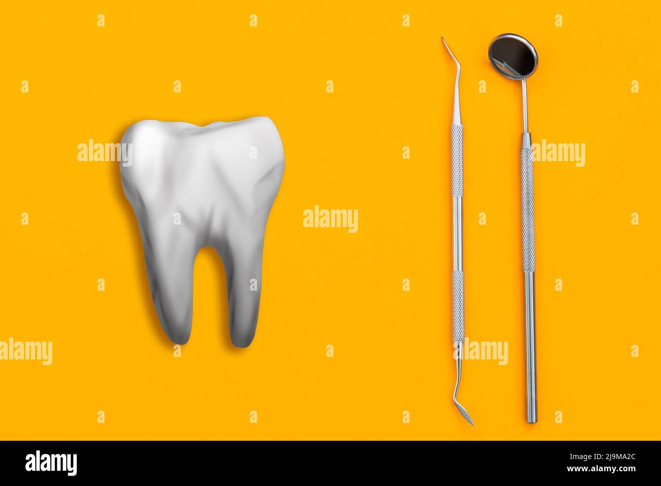 Artificial tooth and dental instrument on table. Dental services