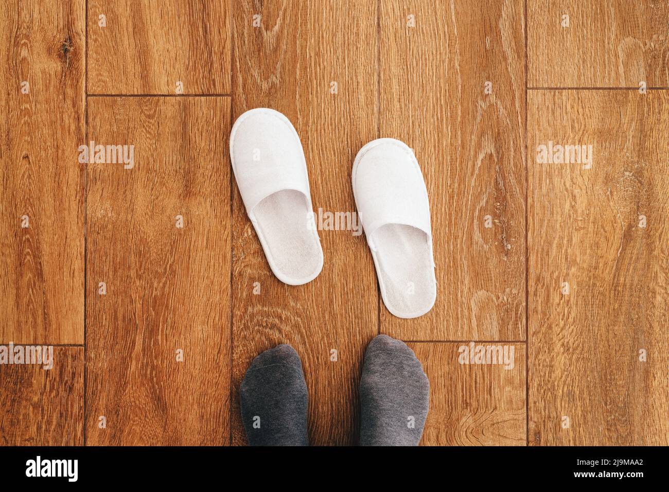 Male feet and disposable white slippers in hotel room, top view Stock Photo  - Alamy
