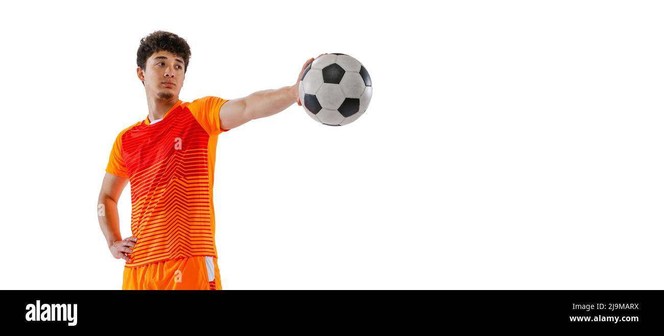 Portrait of young man, asian football, soccer player posing with ball isolated on white studio background. Concept of sport, match, active lifestyle Stock Photo