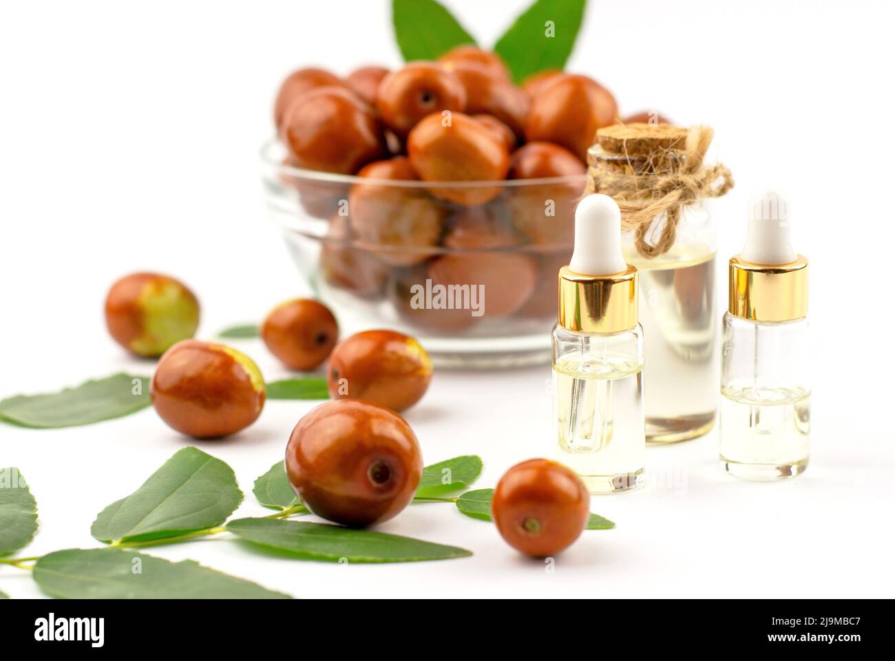 Jojoba oil in a bottle with a dropper and fresh jujube fruit Stock Photo