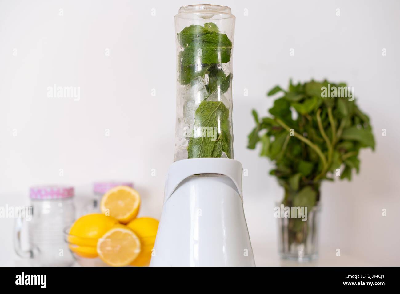 Classic Mint and Lemon healthy cocktail with fruit juicer machine.  Wellness food or detox smoothie for a healthy lifestyle concept. Stock Photo