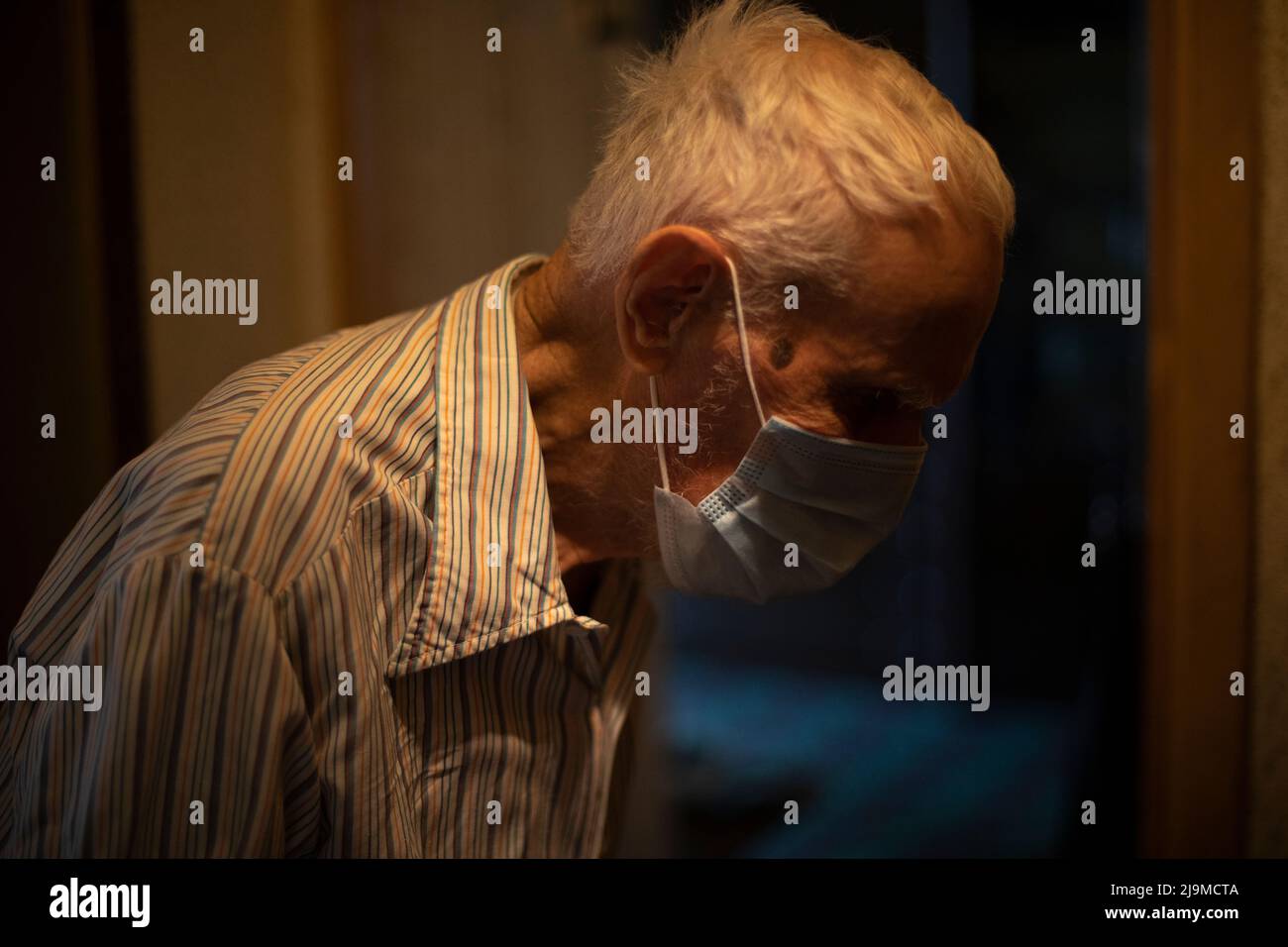 Old man in mask. Elderly man in apartment. Pensioner in house. Grizzled man. Man of 90 years. Stock Photo