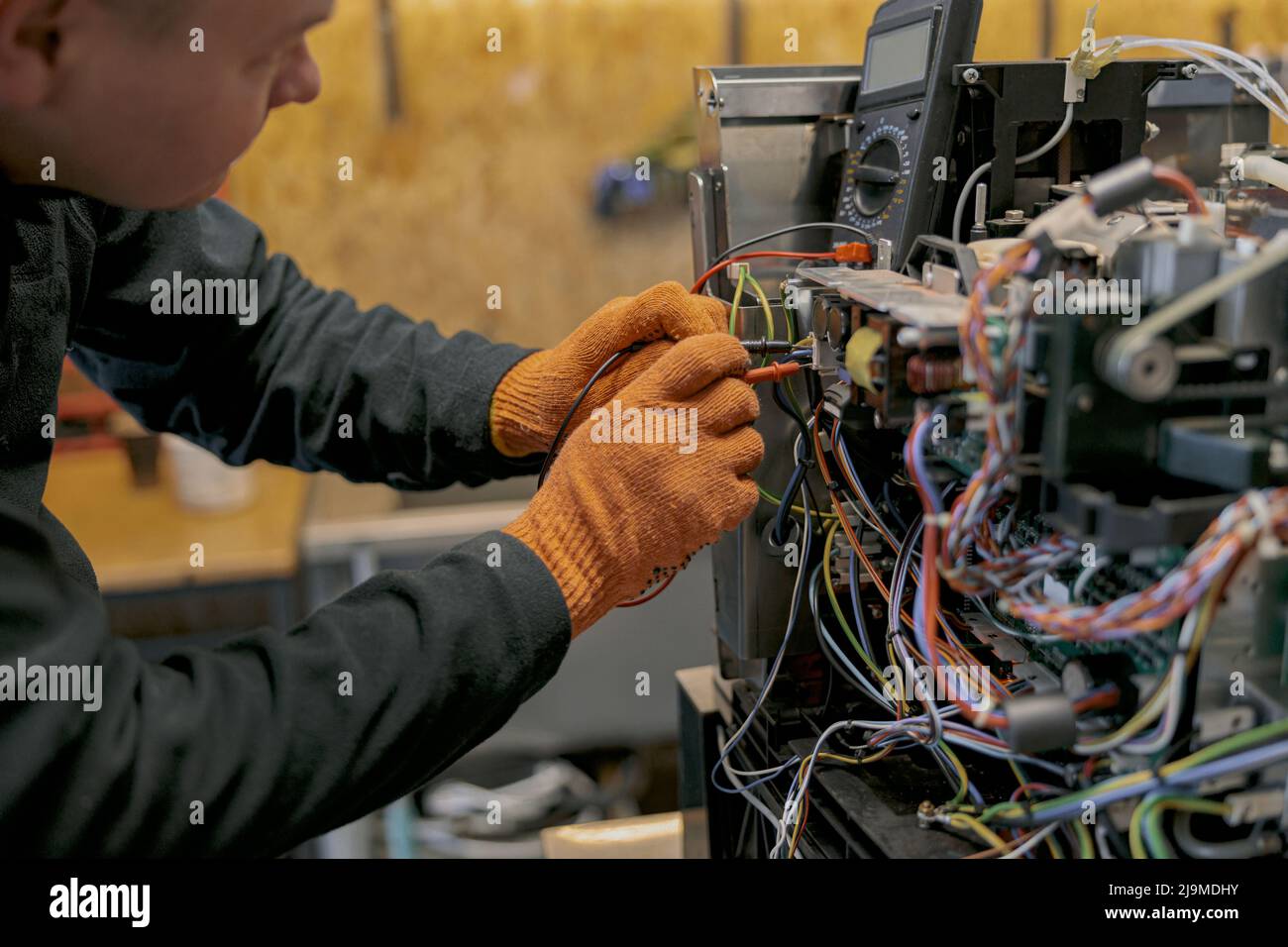 Professional worker fixing coffee machine in workshop Stock Photo