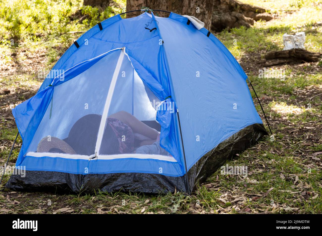 Woman sleeping in tent in field Stock Photo