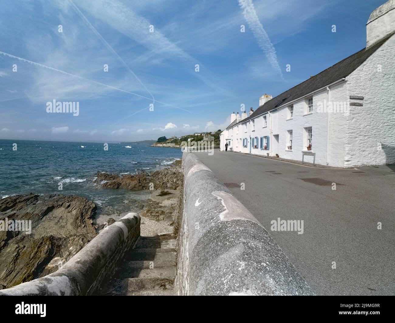 A terrace of white-painted cottages facing the sea in St. Maws, Cornwall, UK Stock Photo