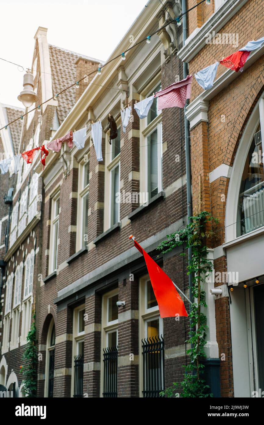 Low angle of laundry hanging on clothesline above street near