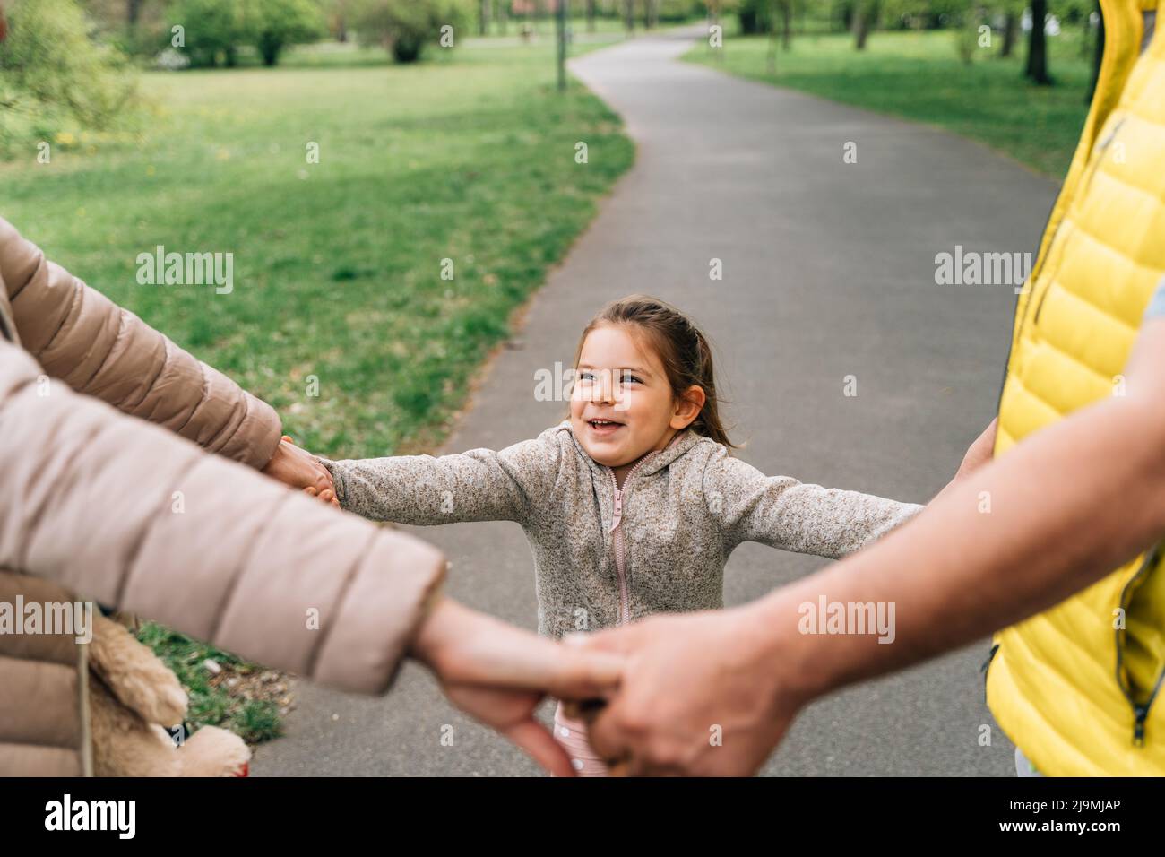 Crop mature grandparents in casual clothes holding hands of adorable