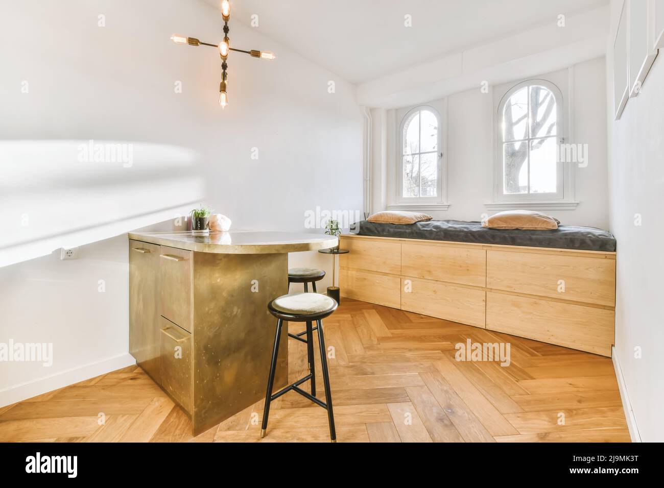 Contemporary gold kitchen island located in middle of light open plan