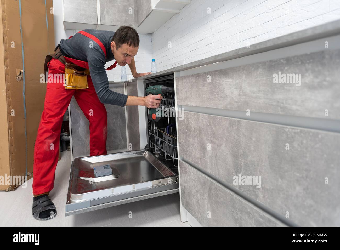 Handyman fixing kitchen's with screwdriver Stock Photo Alamy