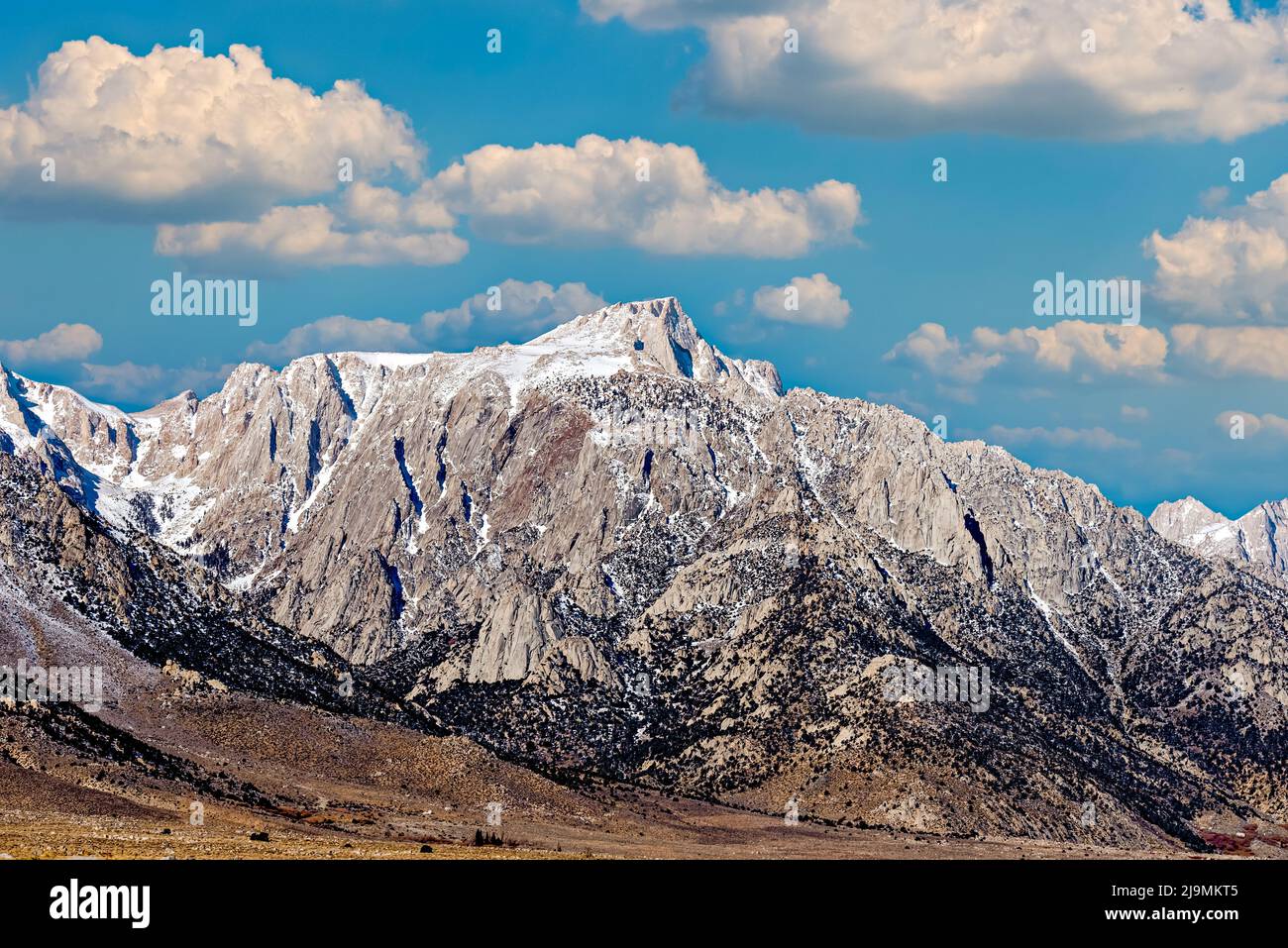 Snow capped Rocky Mountains under Blue skies with white fluffy clouds ...