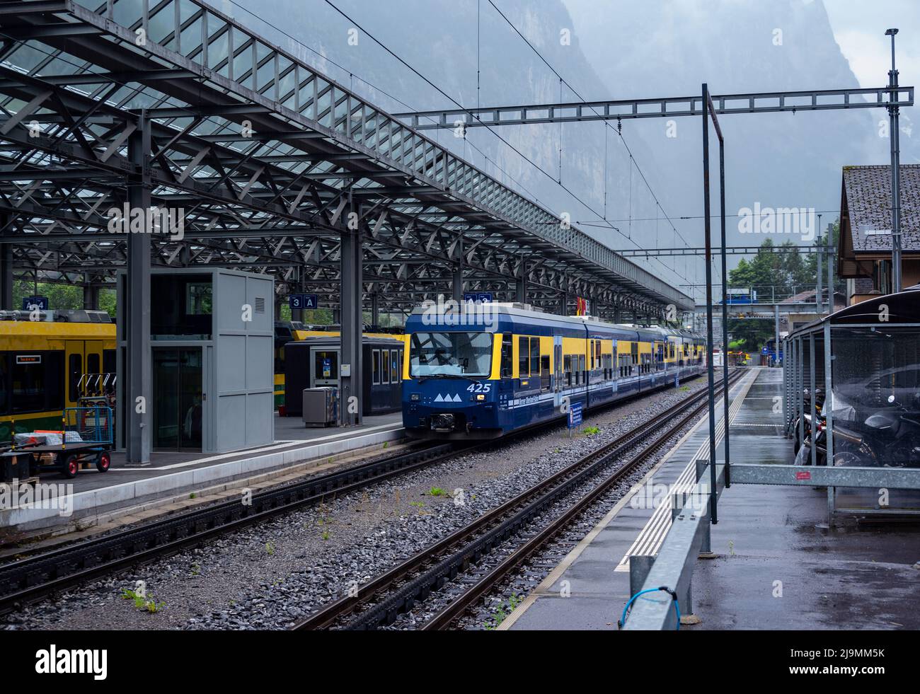 View of the blue -yellow Bernese oberland Bahn train at the platform of the Interlaken Ost station, Switzerland. Stock Photo