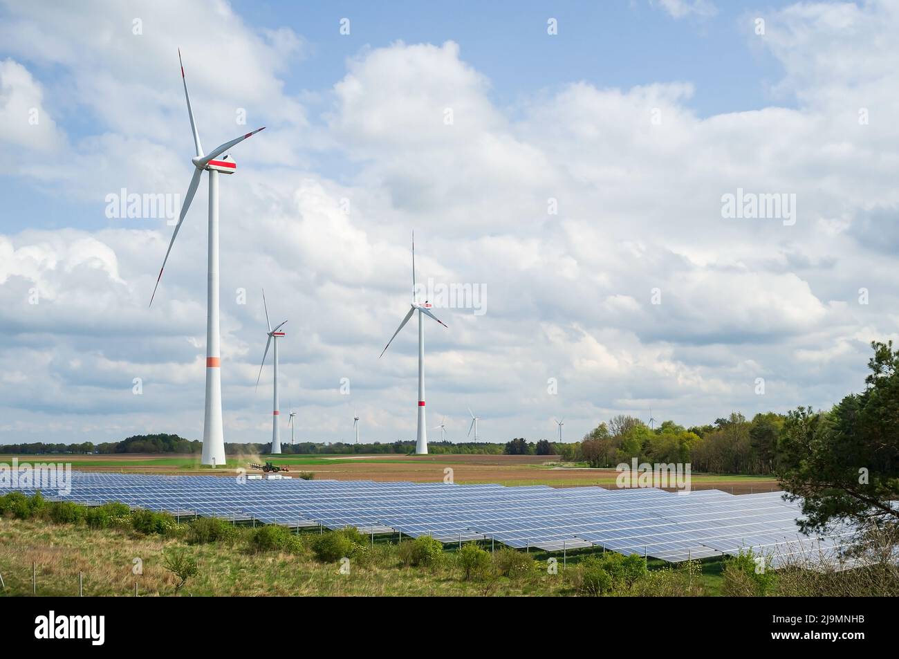 Farm with solar panels and wind turbines, against the background of the ...