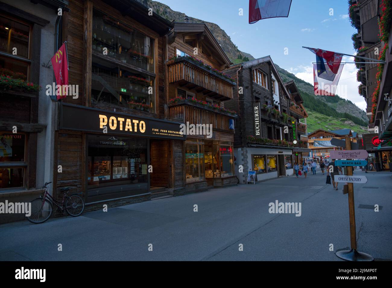View of souvenir shops at the main shopping street of Zermatt a car