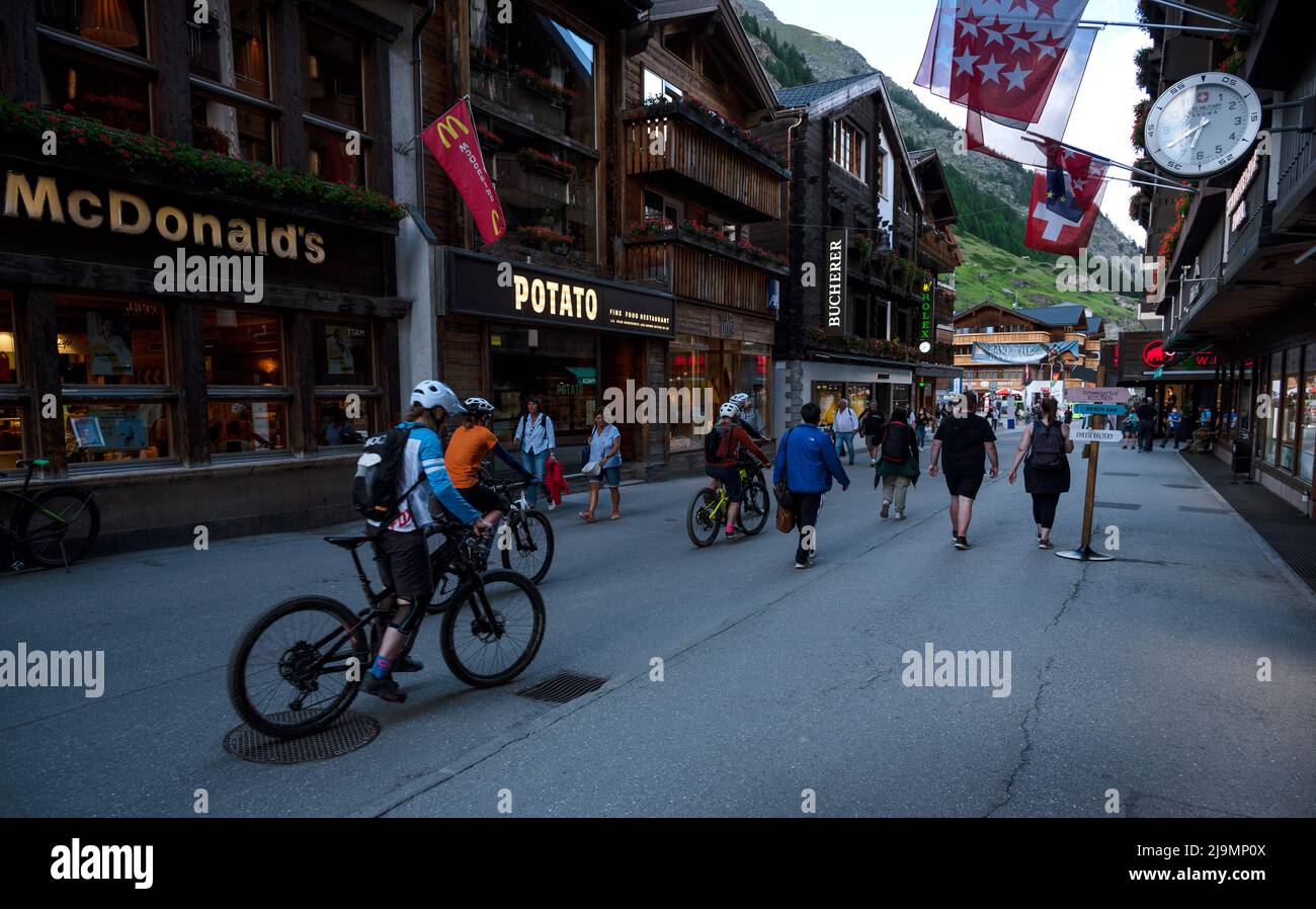 View of souvenir shops at the main shopping street of Zermatt a car