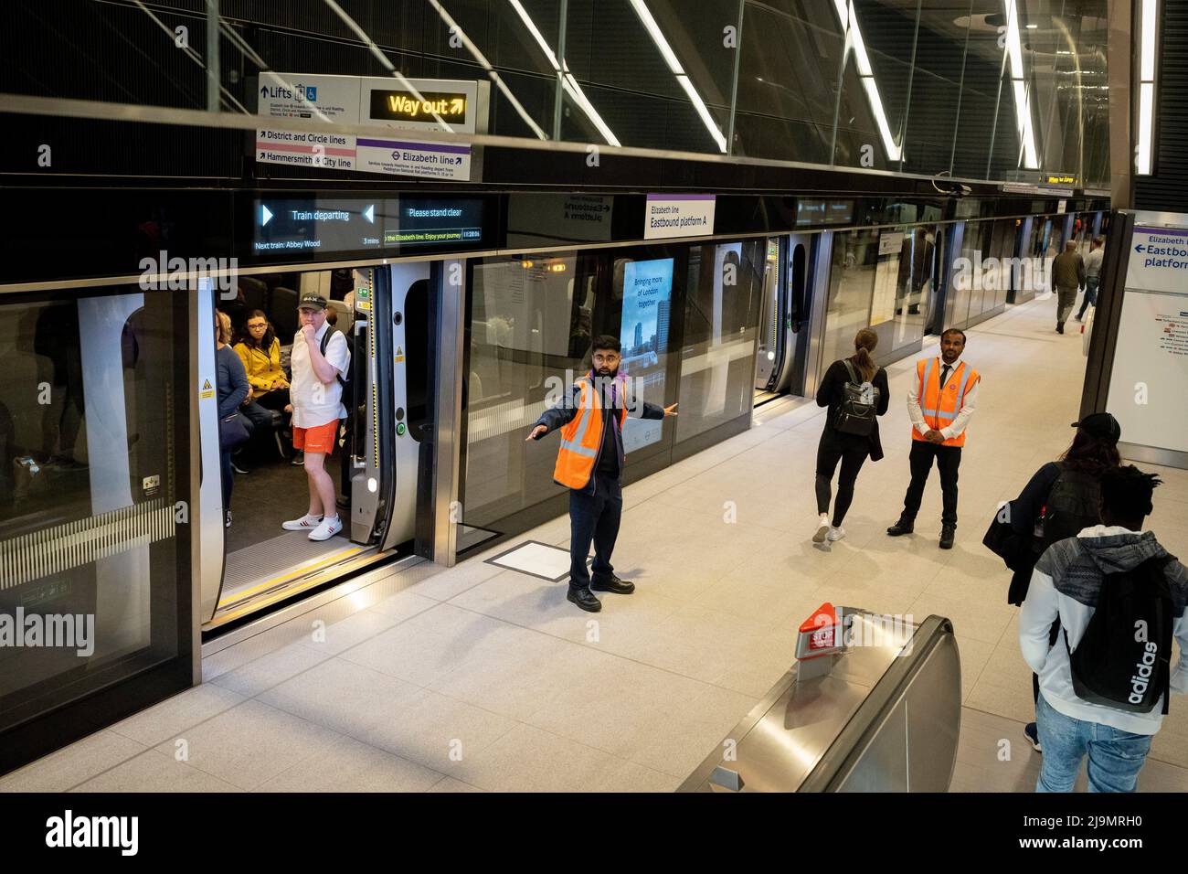 TFL staff provide assistance to passengers on the day that the capital's Elizabeth Line finally opens, on 24th May 2022, in London, England. The Elizabeth Line is London's newest subterranean rail system operating between between Paddington and Abbey Wood but has opened controversially three and half years late, and £4bn over-budget. Stock Photo