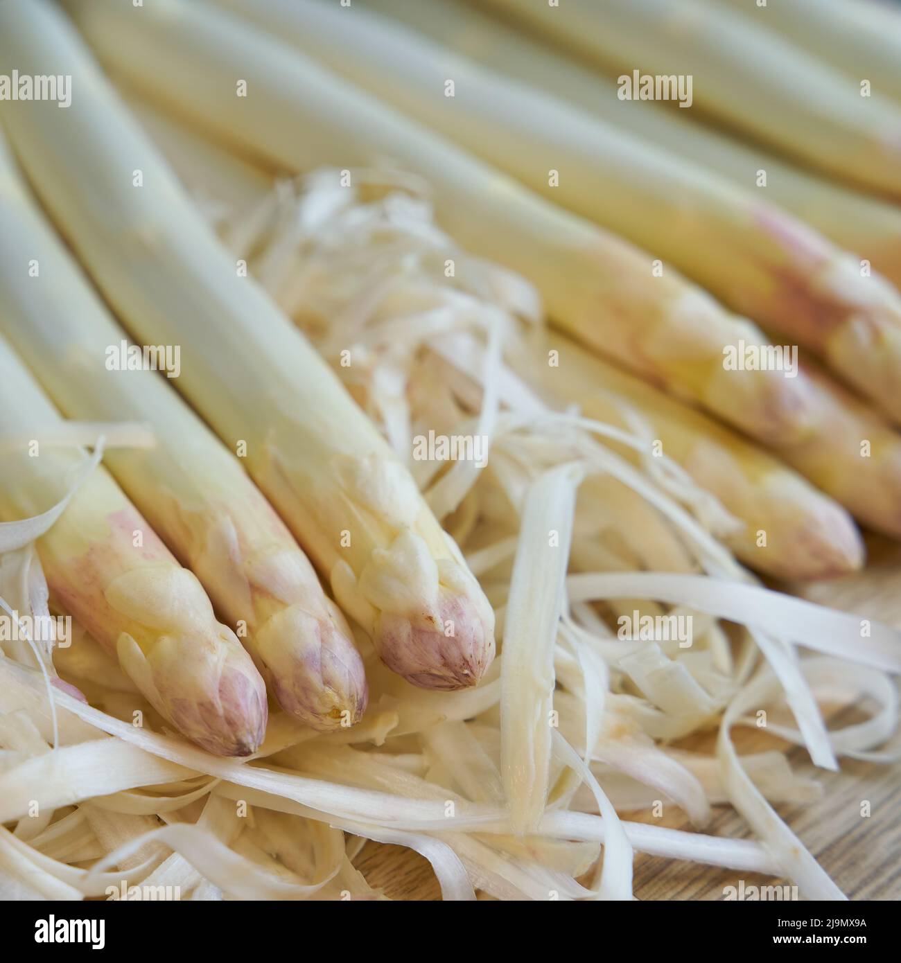 https://c8.alamy.com/comp/2J9MX9A/peeled-white-asparagus-on-a-kitchen-table-2J9MX9A.jpg