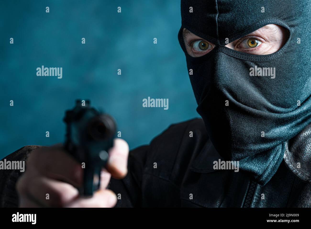 portrait of a thief with balaclava and gun. crime concept Stock Photo
