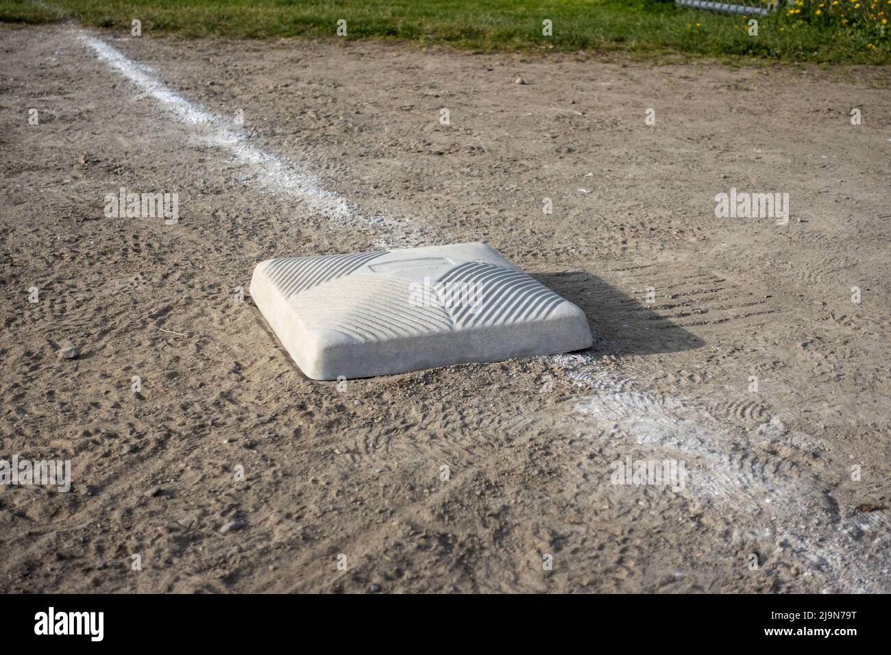 Top down, close up view of a base on a clean baseball field on a bright, sunny day Stock Photo
