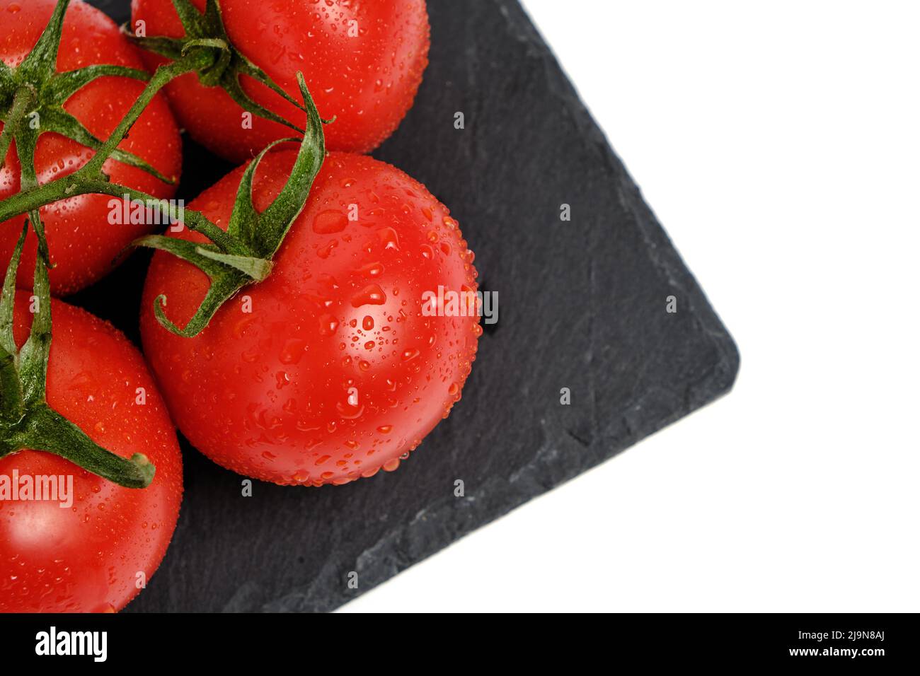 Tomatoes on a slate cutting board, isolated white background Stock ...