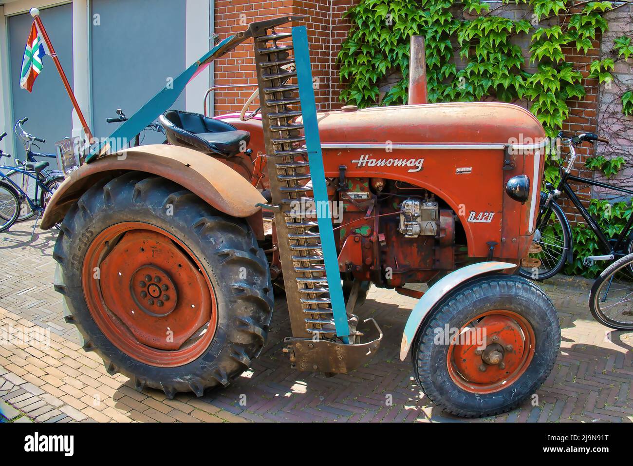 Vintage Hanomag R420 tractor with disc harrow at a classic car show in Uithuizen, Groningen, the Netherlands. Stock Photo