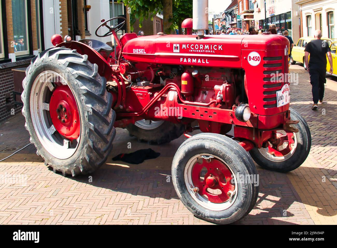 Vintage red McCormick International Farmall  B450 tractor on a classic car show in Uithuizen, Groningen, the Netherlands. Stock Photo