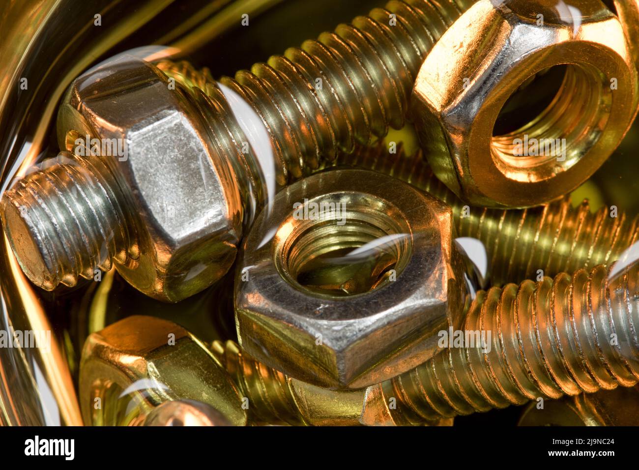 Metallic nuts and bolts in lubrication oil Stock Photo Alamy