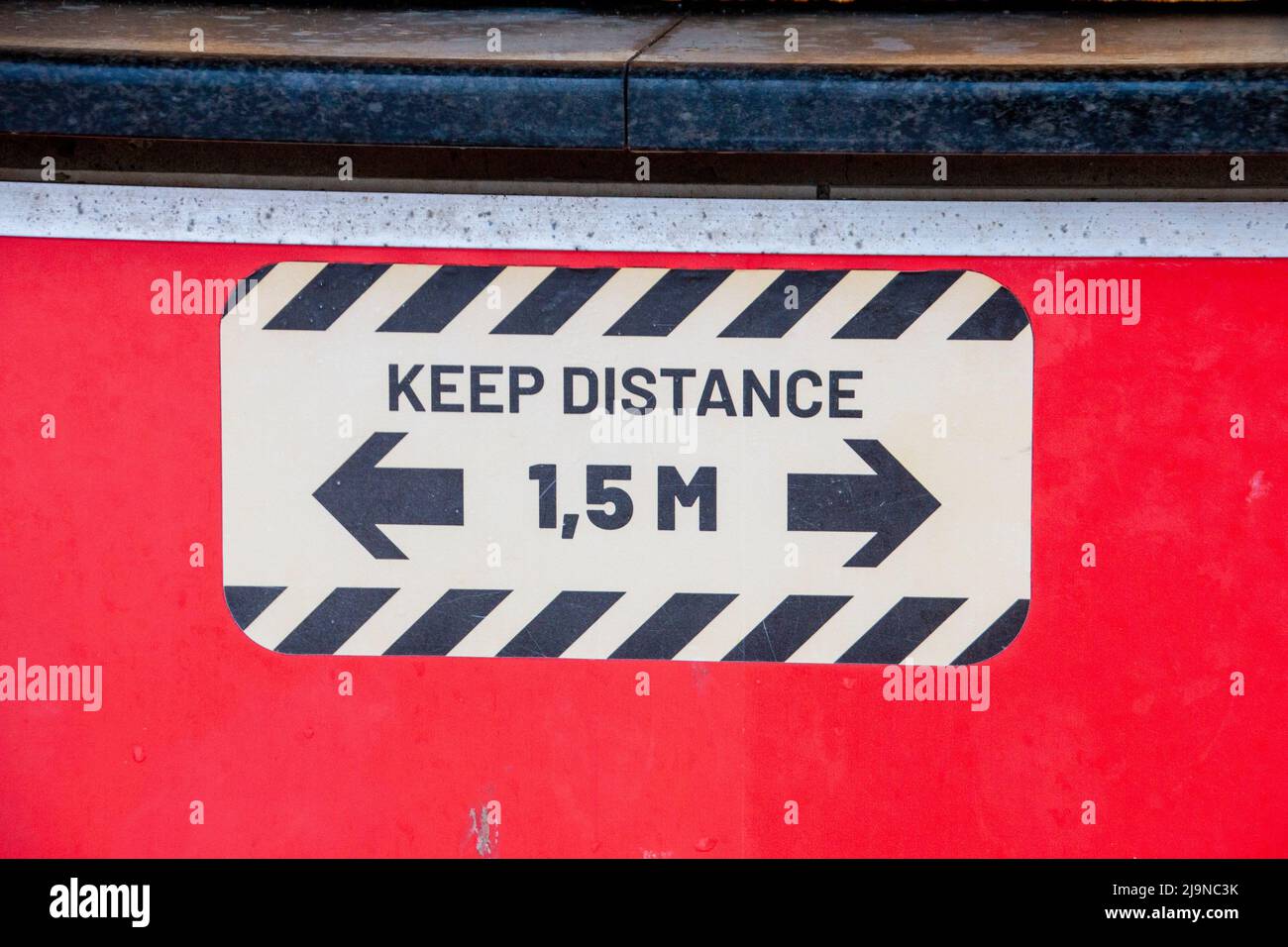 A close up view of a keep distance sign in a public area. Stock Photo