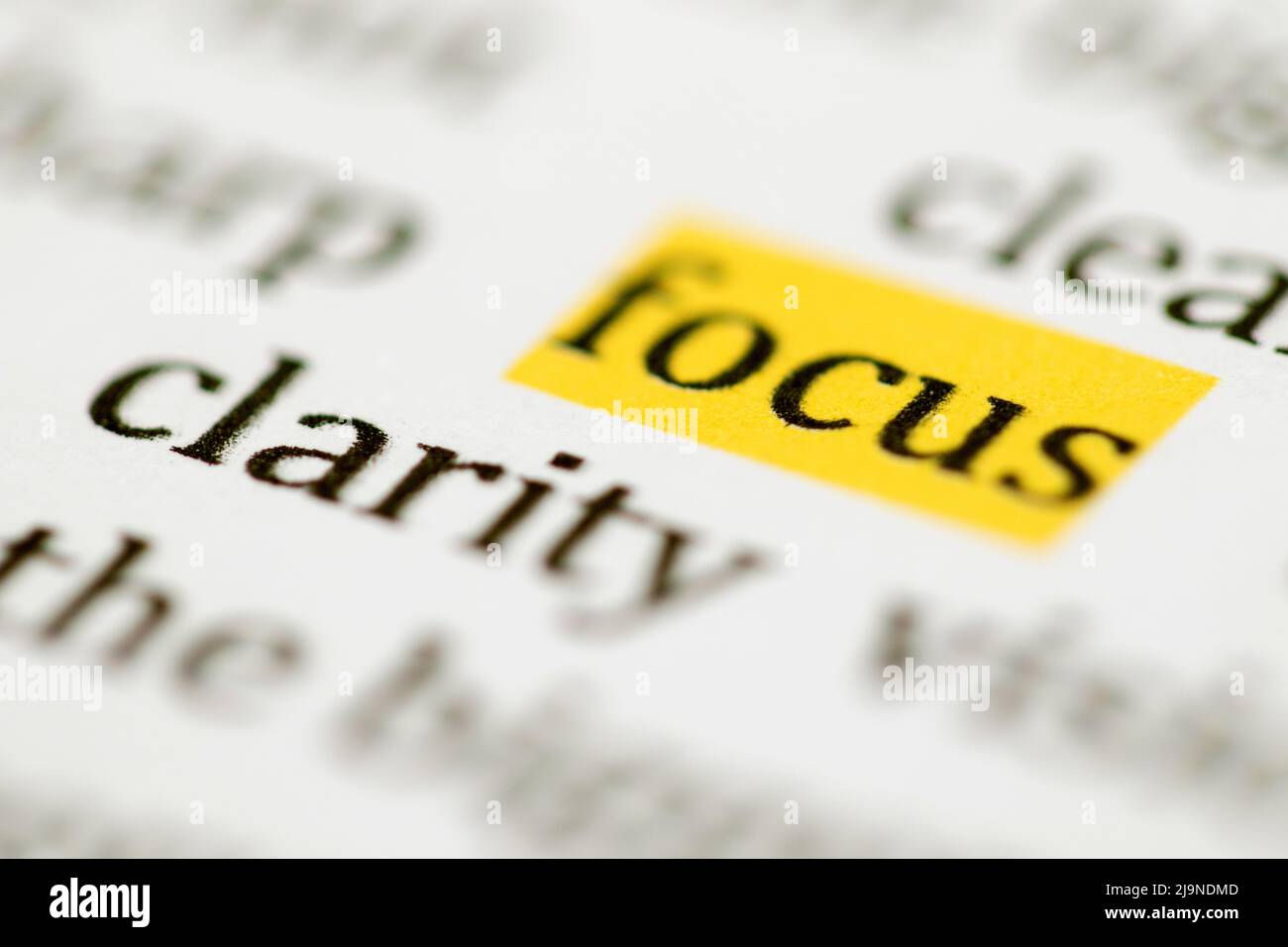 Close up of the typed word focus highlighted in yellow and printed in black ink on white ink jet paper Stock Photo
